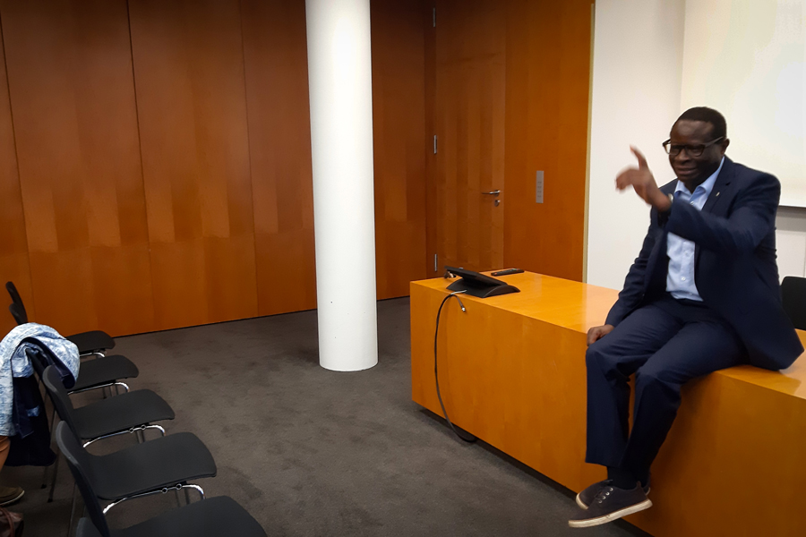 Eine sitzt sprechend auf einem Tisch.