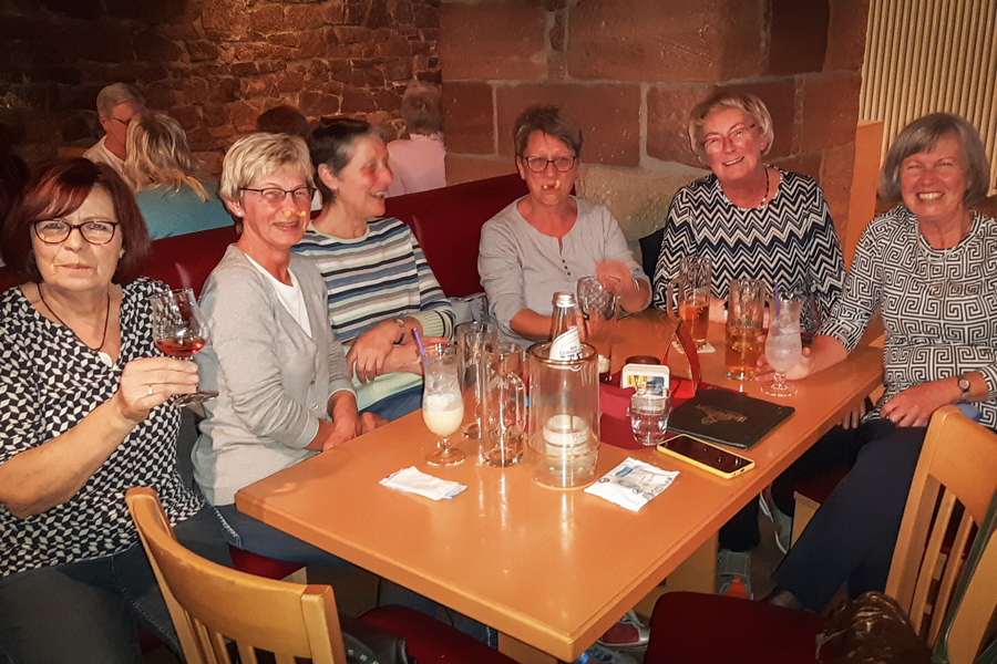 Frauen sitzen einem Tisch und blicken in die Kamera
