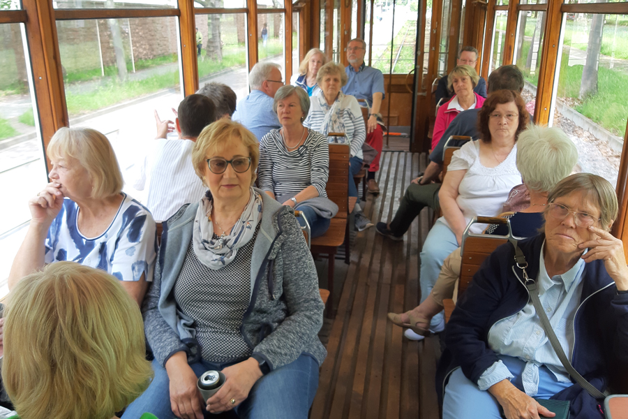 Personen sitzen in einer historischen Straßenbahn