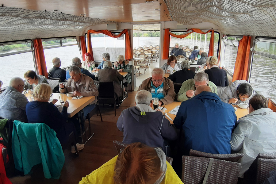 Personen sitzen unter Deck und Essen