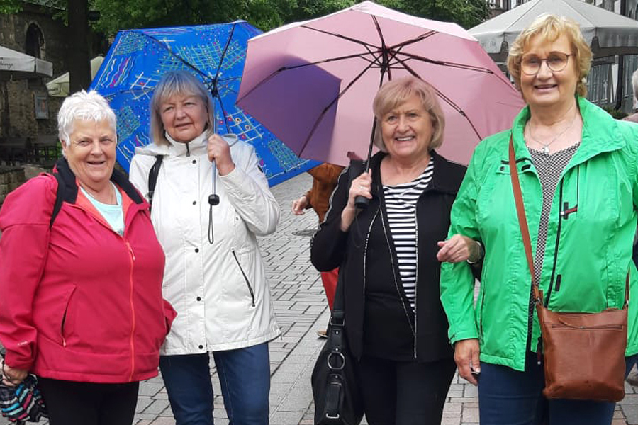 4 Damen lächeln in die Kamera